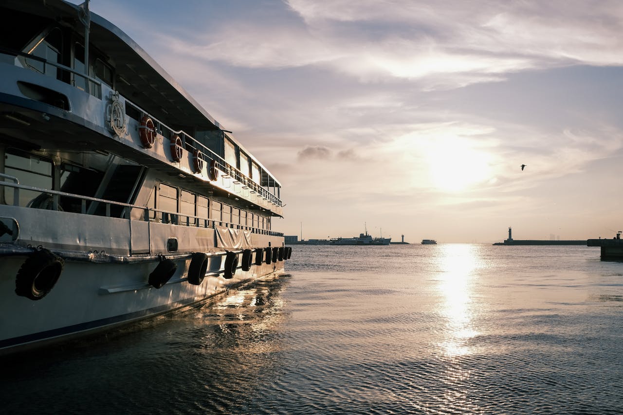 A picturesque view of a yacht moored at a harbor during a serene sunset, enhancing a tranquil ambiance.